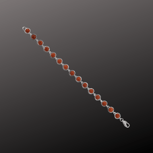 Silver bracelet with red gemstones on a dark gray background
